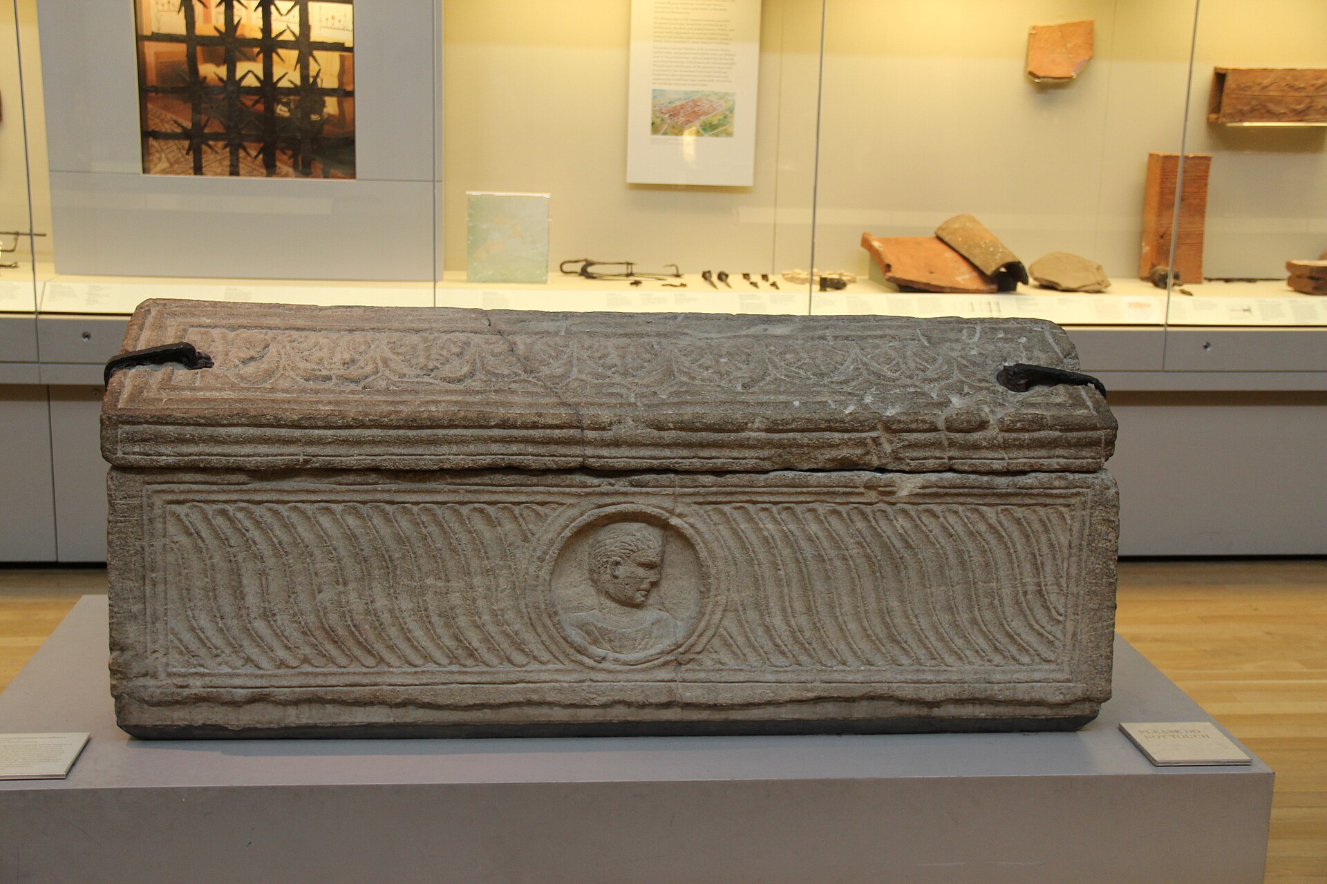 Carved Roman stone coffin in a museum gallery