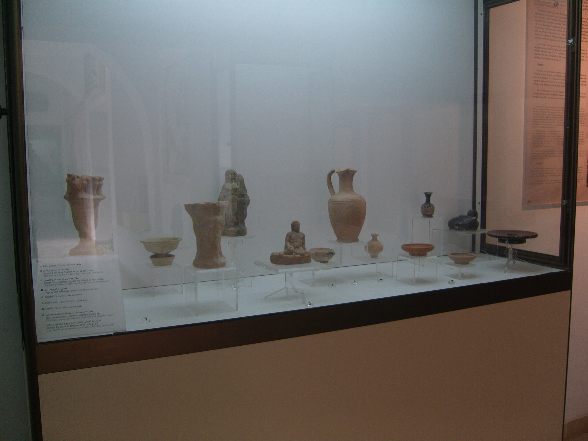Ancient lamps, statuettes and ceramic dishes in a museum display
