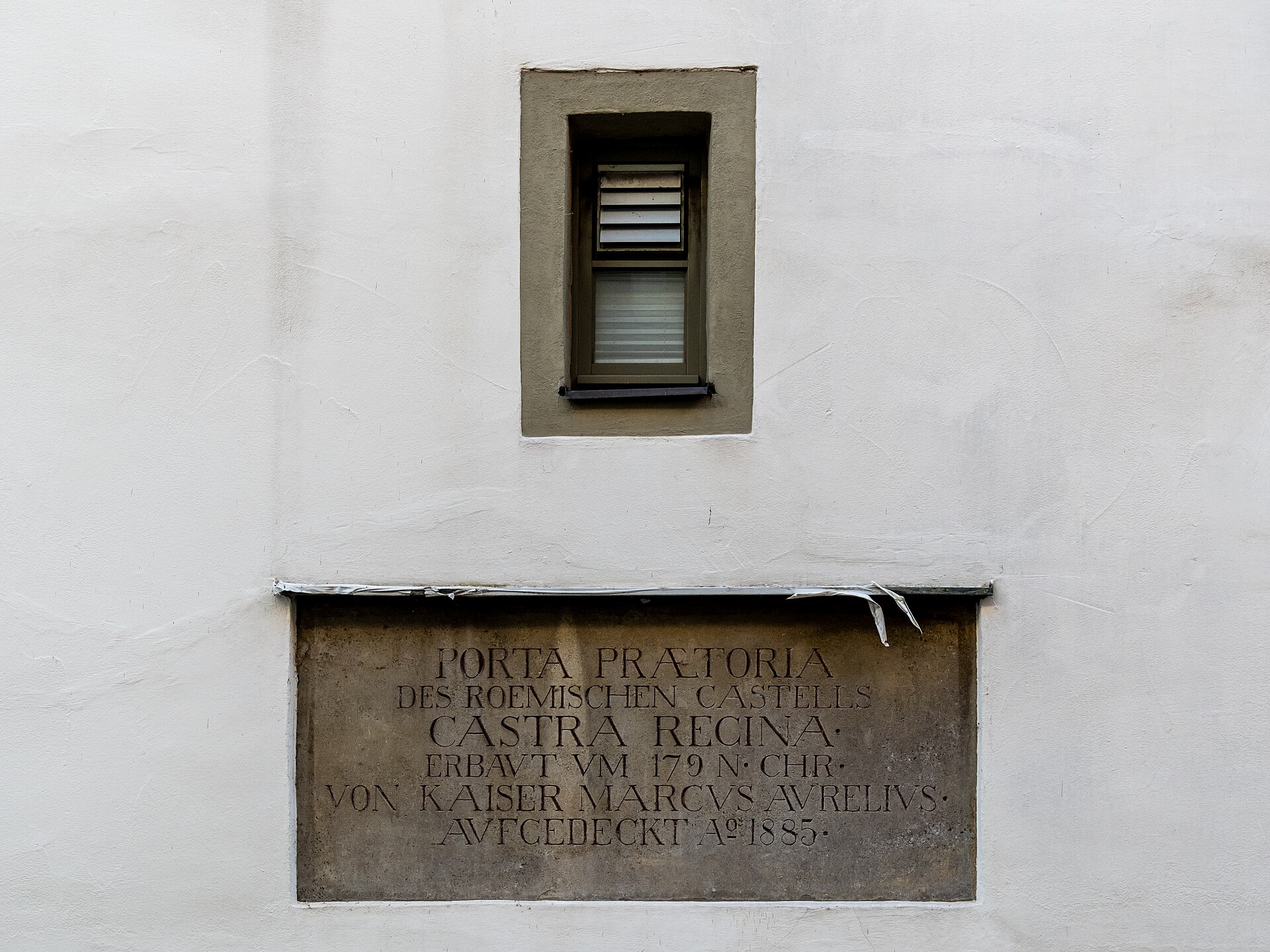 Remains of a Roman stone gateway with a large arch built into later buildings in Regensburg