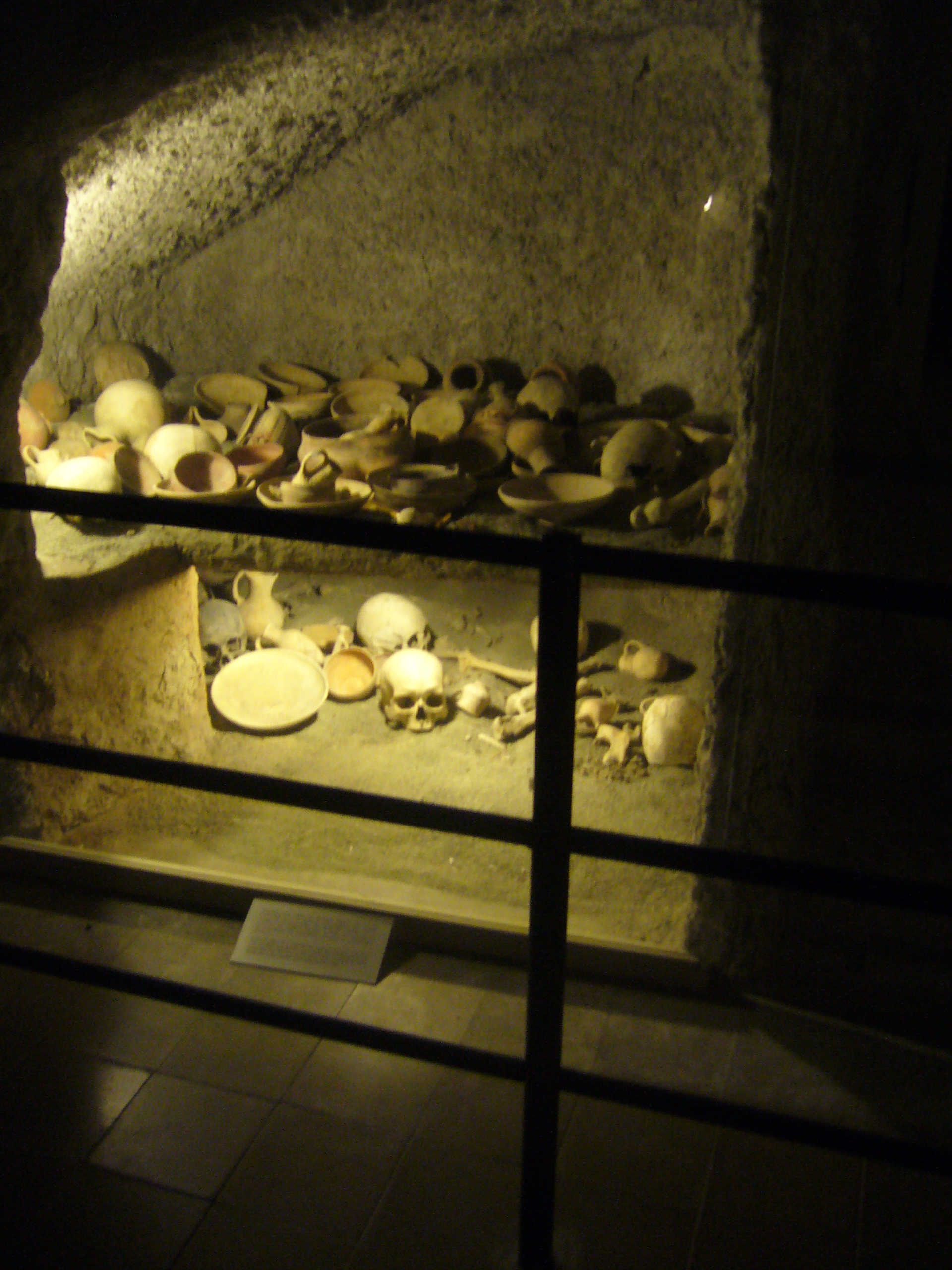 Museum reconstruction of a Late Bronze Age rock-cut chamber tomb with burials and pottery on two levels
