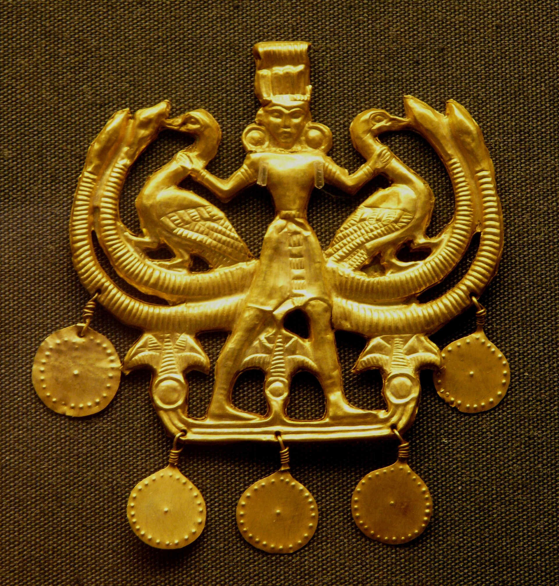Gold pendant of a figure holding two birds