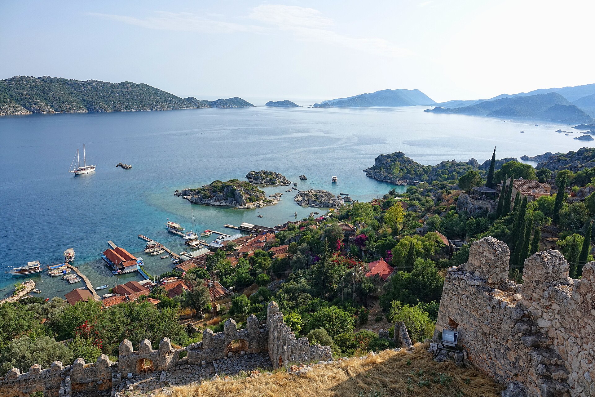 View over a village and blue sea toward the long, rocky Kekova Island