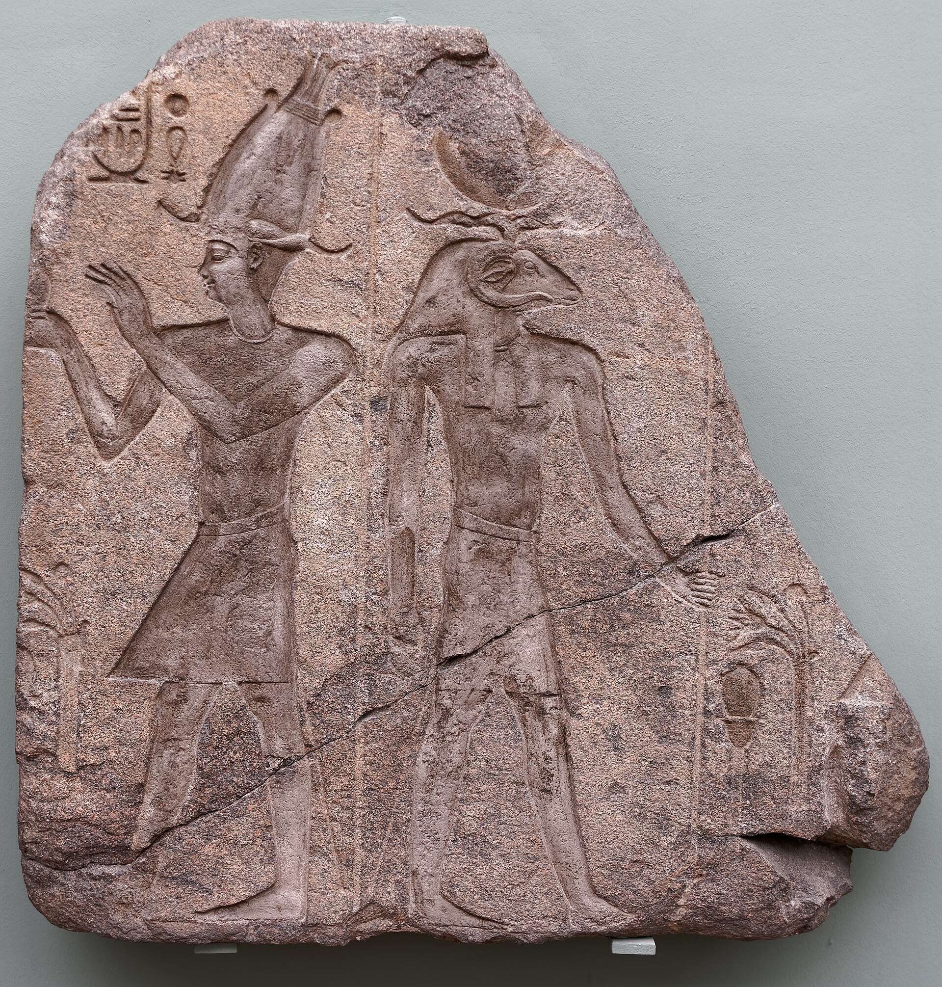 Carved stone relief of a king facing a ram-headed god