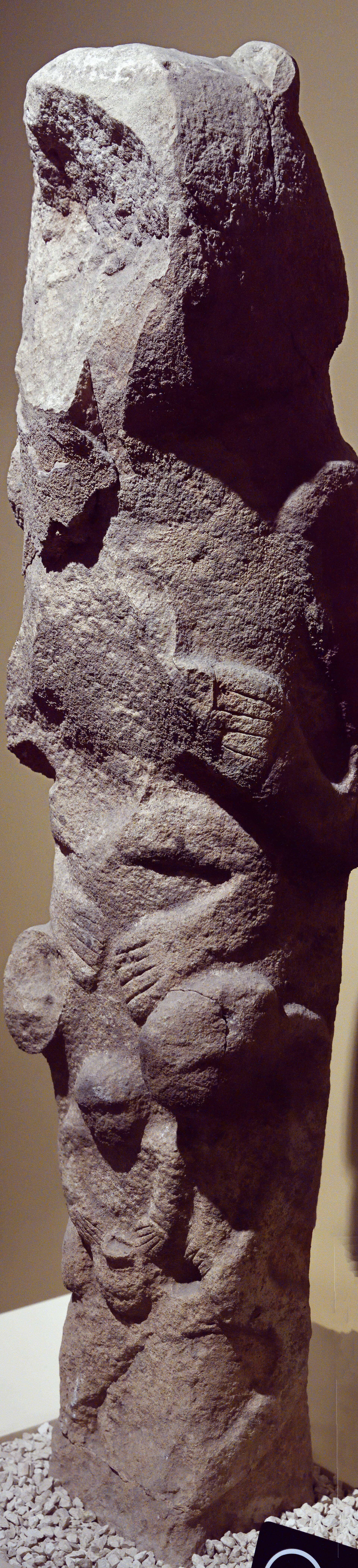 Carved Neolithic stone totem with stacked figures