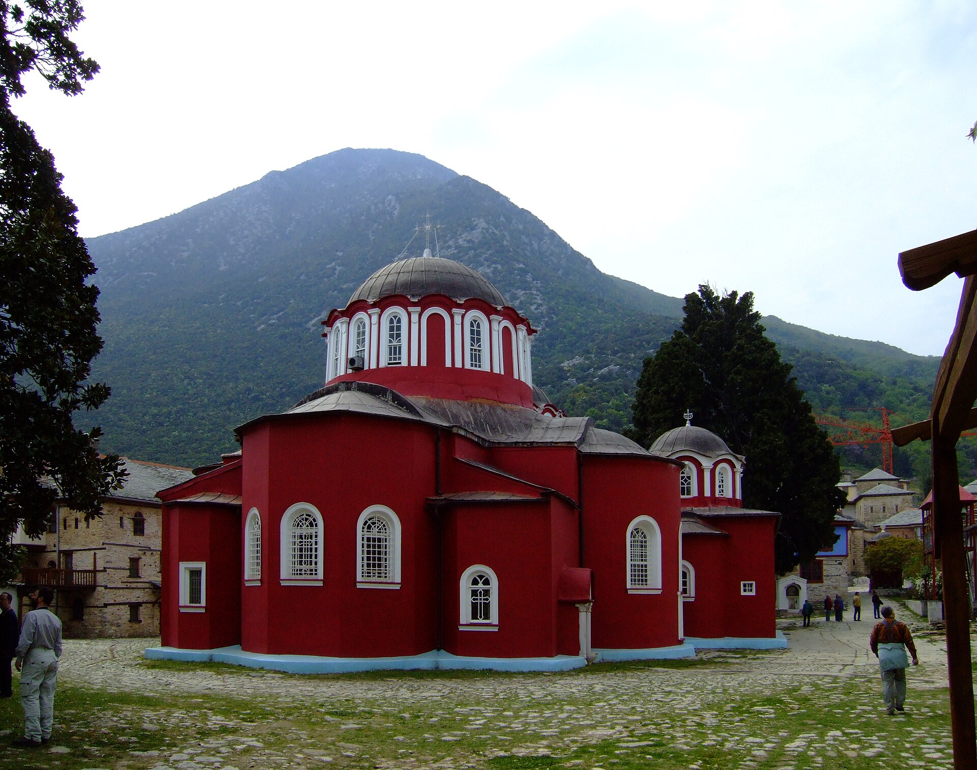 Red-walled Byzantine church with domes inside the Great Lavra monastery courtyard