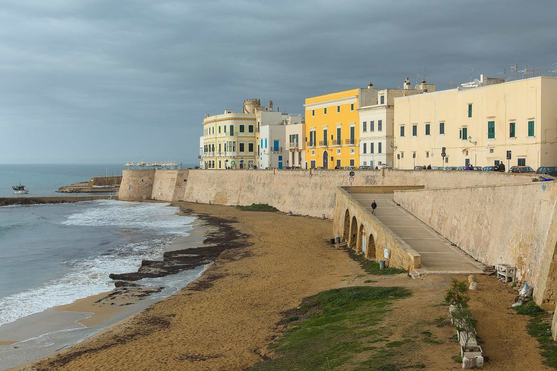 Coastline of Gallipoli, Italy, with a sandy beach beside the old town buildings and the sea